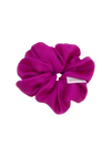 Pink scrunchie with a brand label on a white background