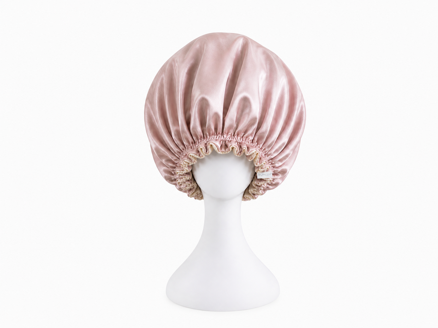 pink ivory satin bonnet on a mannequin head against a white background