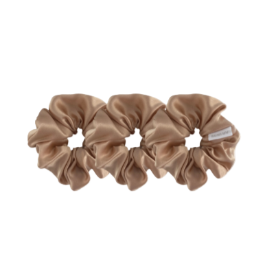 Three beige scrunchies on a white background