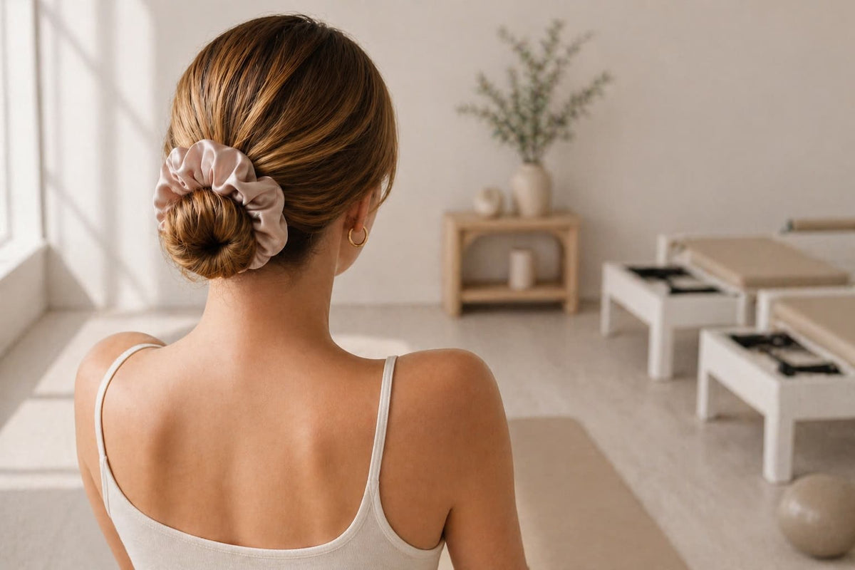 Woman with a bun wearing a nude silk BUNLUV smartcore scrunchie in a yoga studio