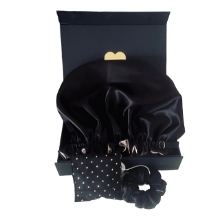 Black satin hair bonnet with matching scrunchie and bow on a white background