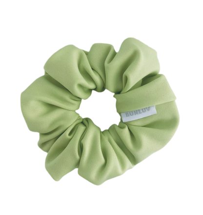 Light green scrunchie with a brand label on a white background