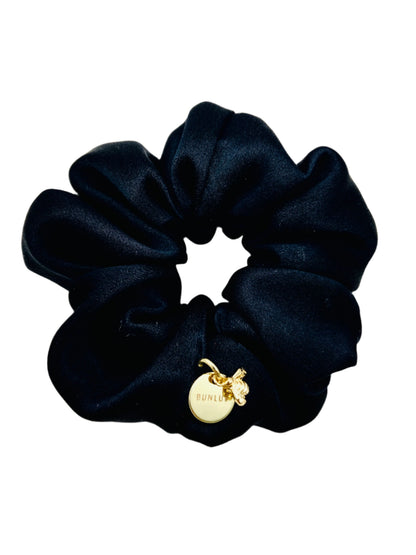 BUNLUV silk scrunchie in black with charm on white background