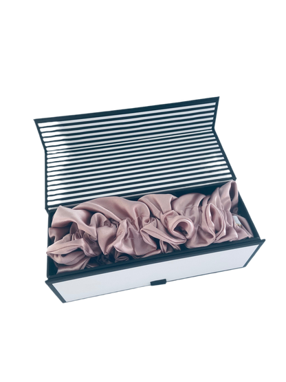 Folded pink bunluv bonnet in a striped box on a white background