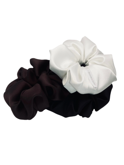 Three scrunchies, one black , one chocolate brown and one white, on a white background