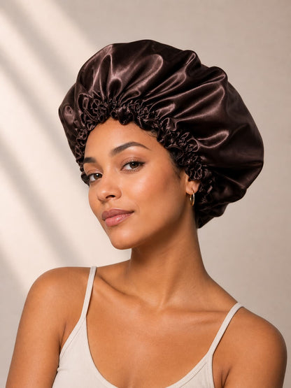 Woman wearing a  bunluv brown and rose gold satin bonnet against a neutral background