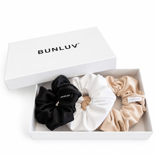 Three BUNLUV scrunchies in black, nude and white are displayed in a white gift box with the lid propped open, which features the BUNLUV brand name original image with AI white background
