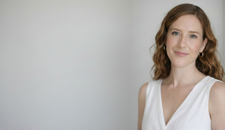 Frances Maloney founder of BUNLUV with wavy brown hair wearing a white sleeveless top against a plain background