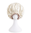 ivory satin bonnet on a mannequin head against a white background