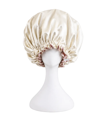 ivory satin bonnet on a mannequin head against a white background