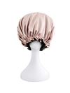 rose gold and black satin bonnet on a white mannequin head against a white background